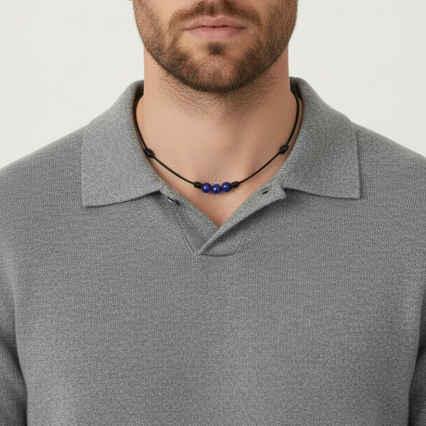 Man wearing a light blue sweater and a necklace with lapis lazuli beads on a white background