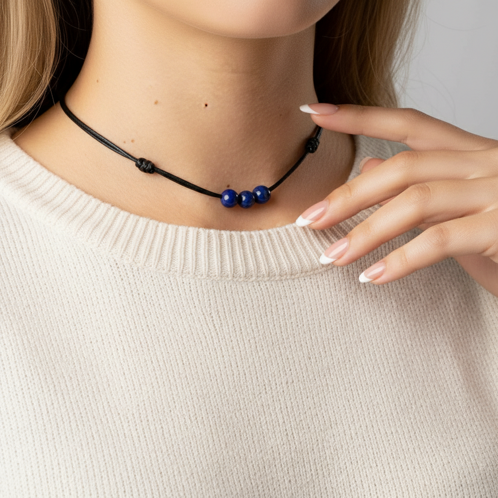 Necklace with lapis lazuli beads worn by a person in a beige sweater.