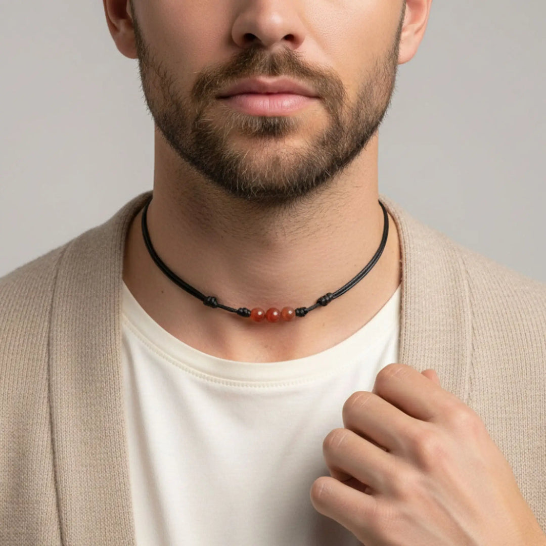 Man wearing a necklace with a neutral background