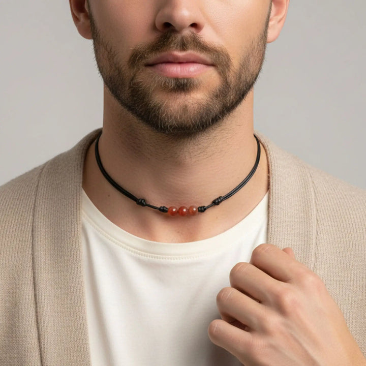 Man wearing a necklace with a neutral background