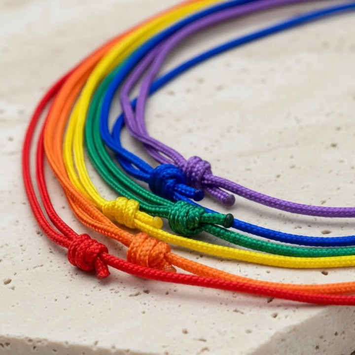 Set of rainbow-colored bracelets on a textured surface