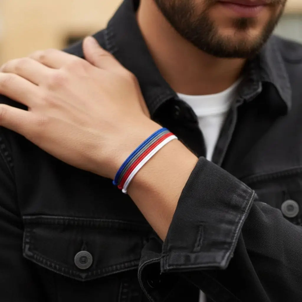 Person wearing a black jacket with a colorful bracelet on a blurred background