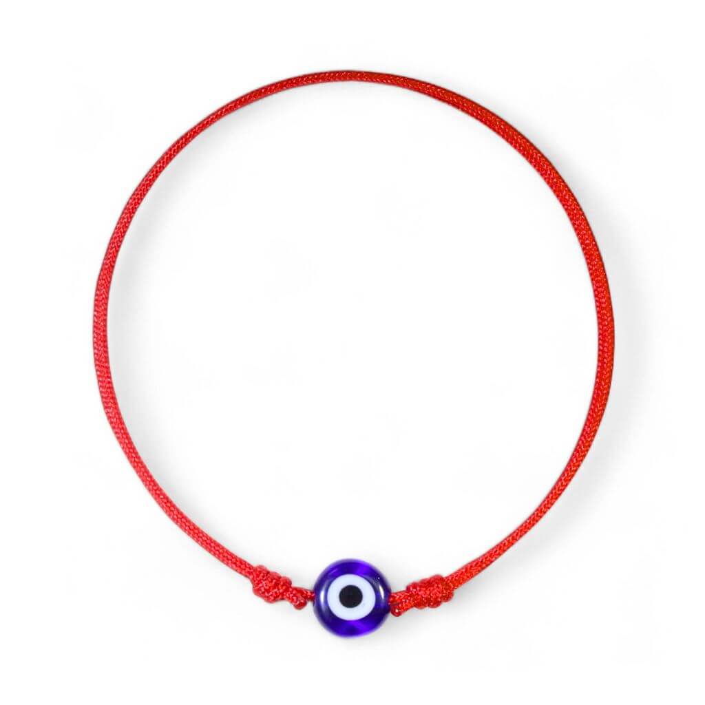 A red bracelet featuring a blue evil eye charm and a red thread.