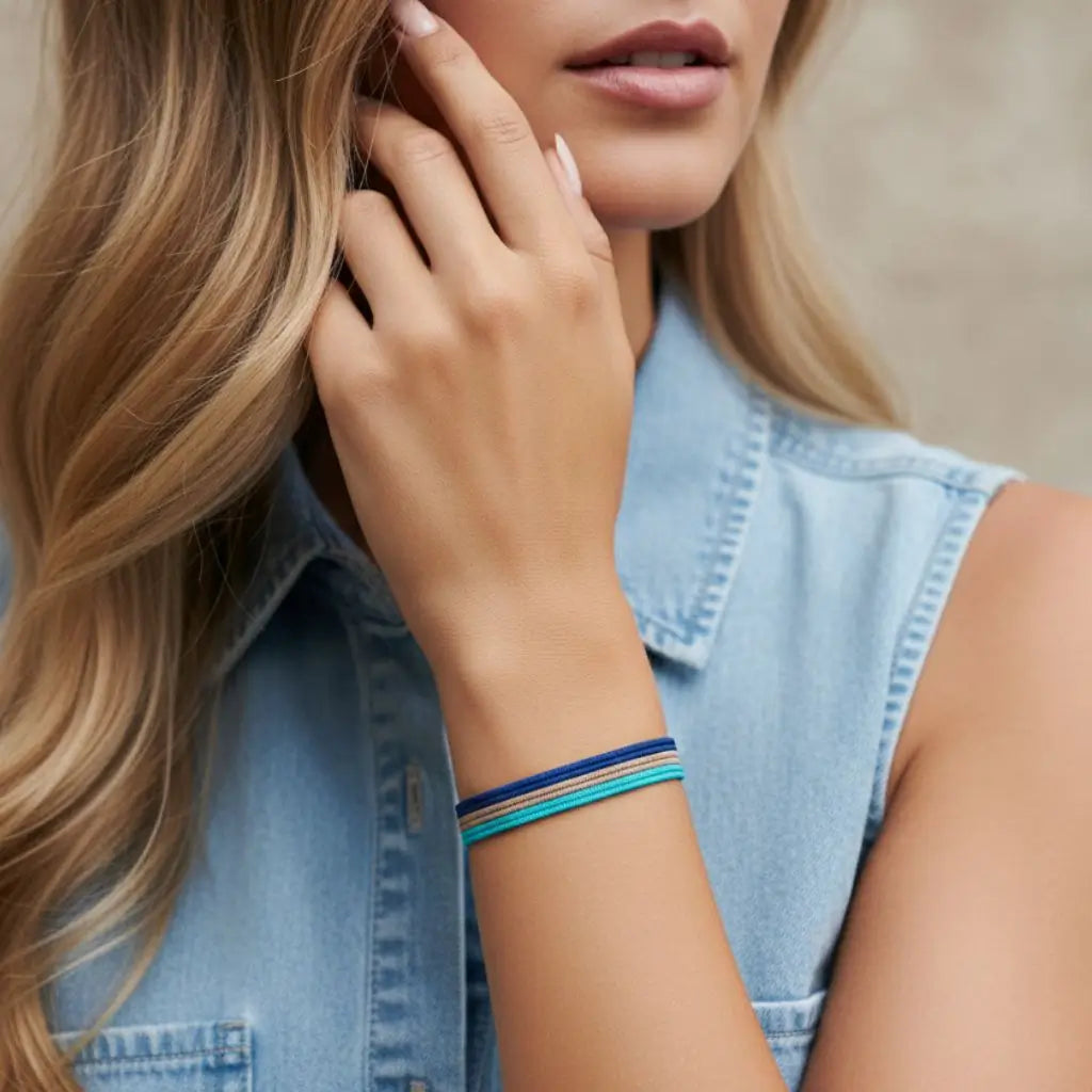 Woman wearing a denim vest and colorful bracelet, with a blurred background