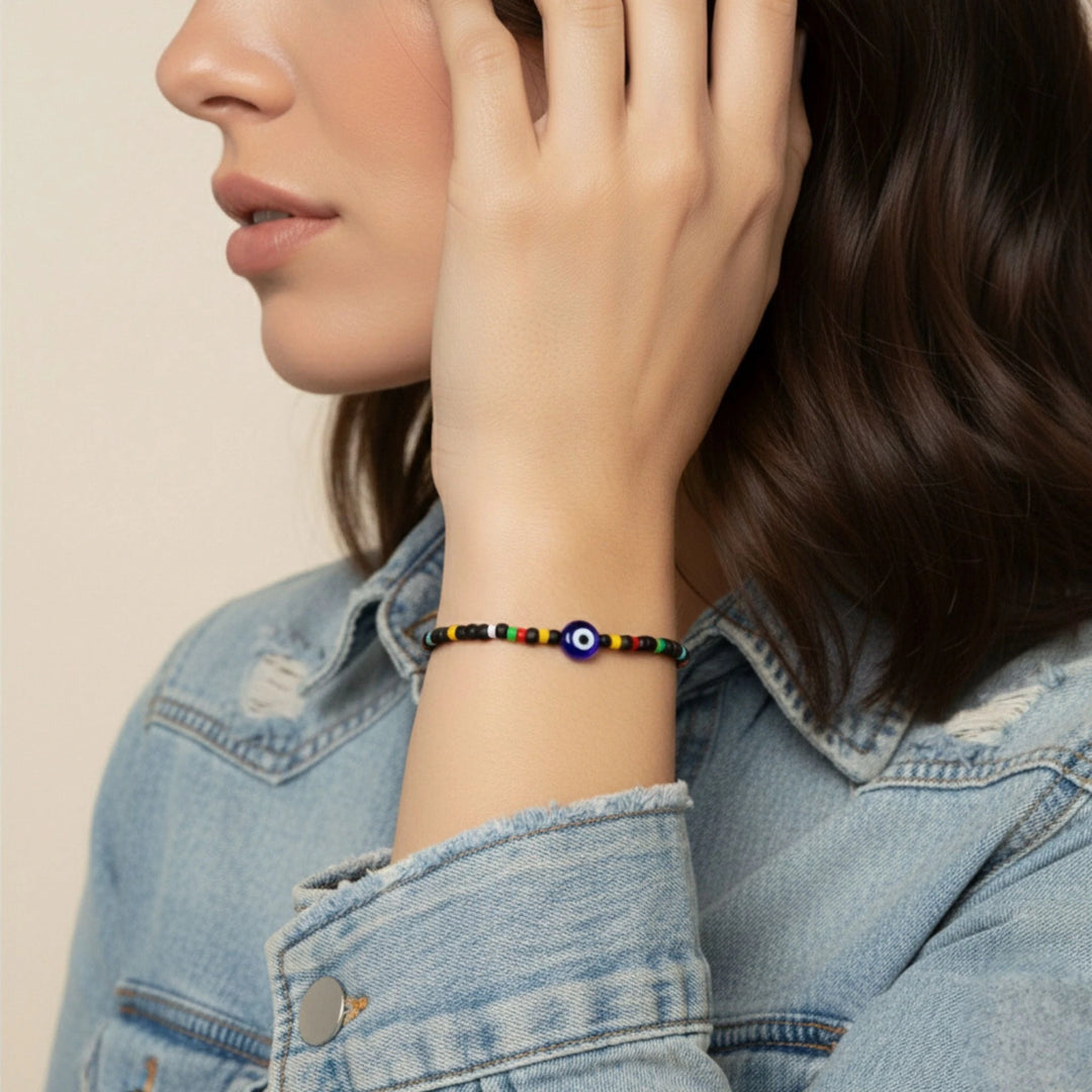 Person wearing a colorful beaded bracelet on a neutral background