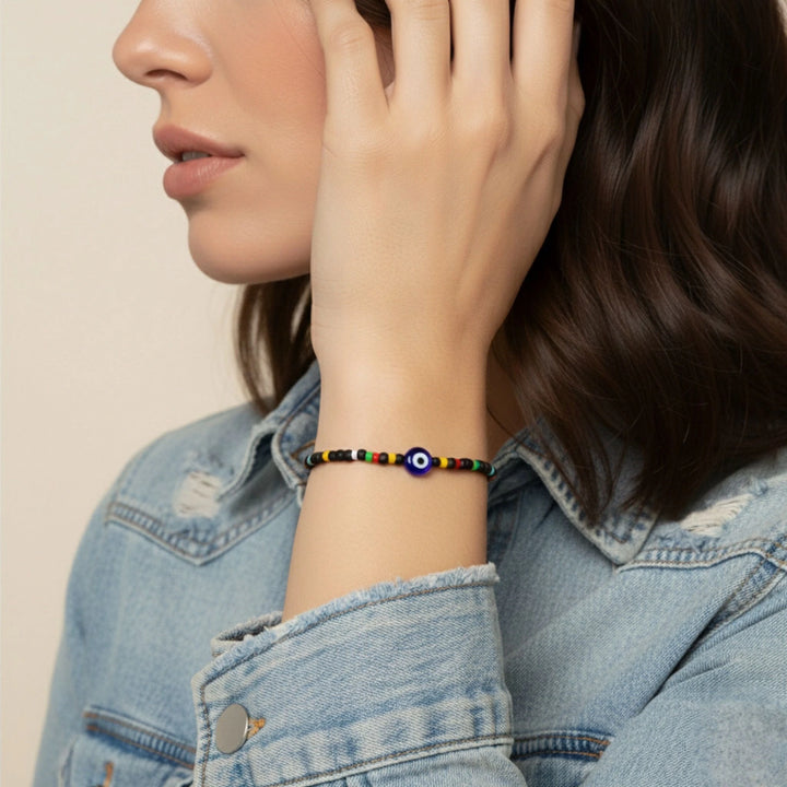 Person wearing a colorful beaded bracelet on a neutral background