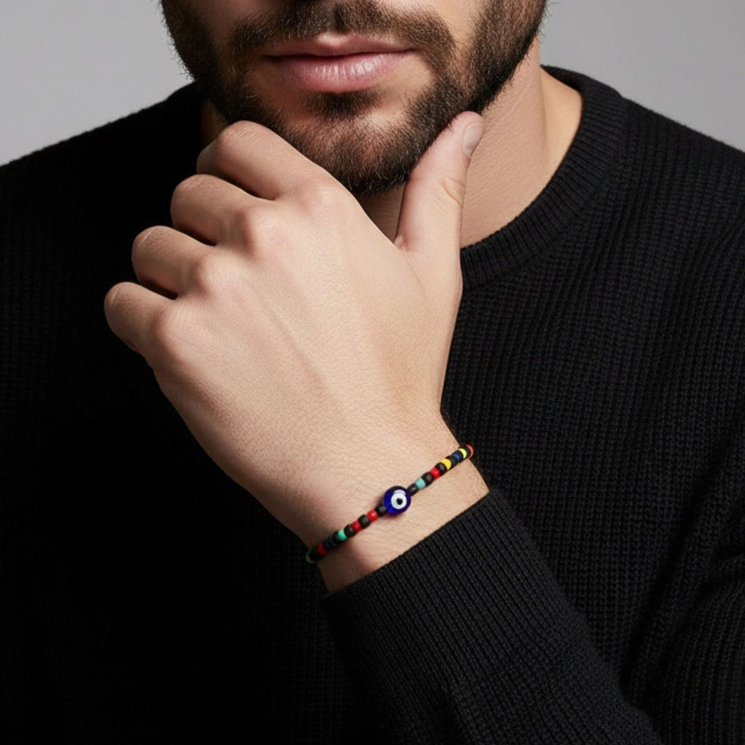 Man wearing a colorful beaded bracelet on his wrist against a neutral background