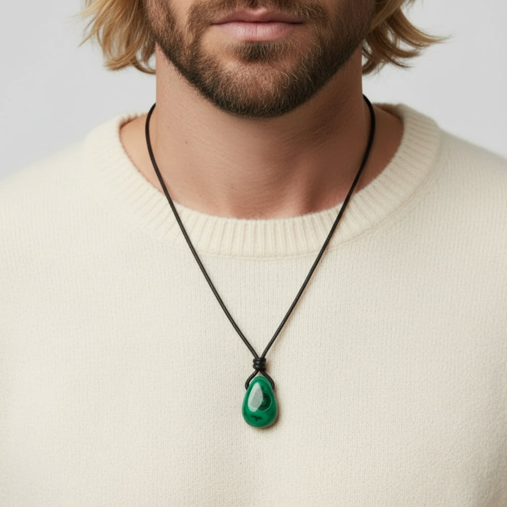 Man wearing a cream sueter with a green malachite pendant necklace.