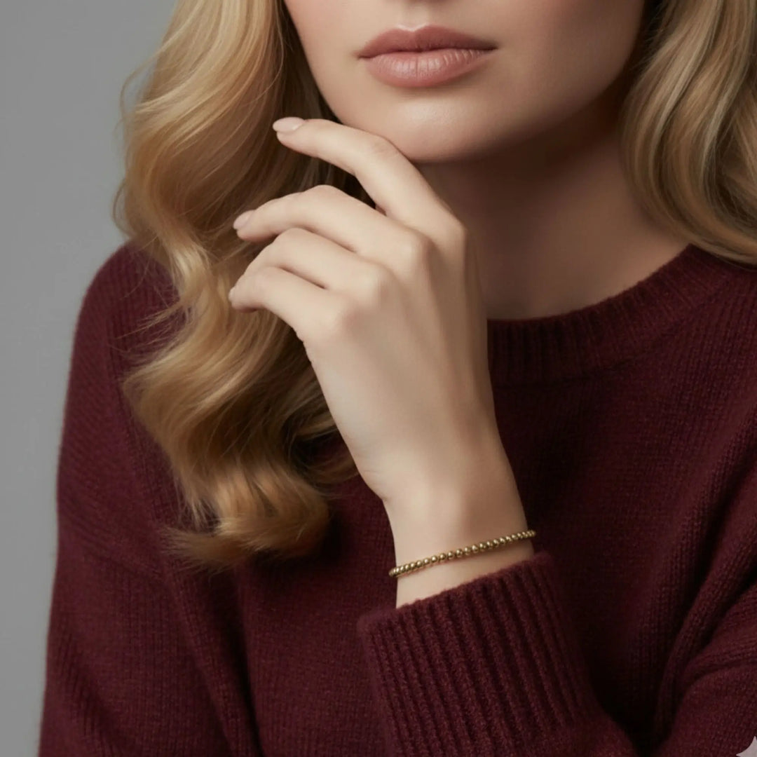 Close-up of a person wearing a maroon sweater with a neutral background
