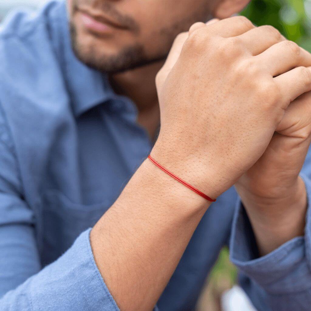 Men wearing a red bracelet 