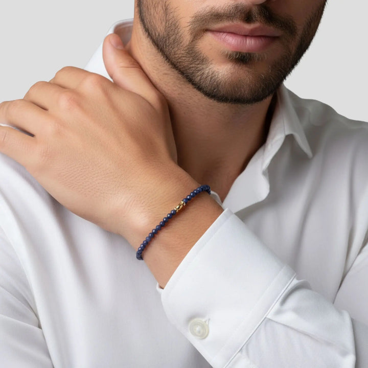 Man wearing a blue sapphire beaded bracelet on his wrist with a white shirt.