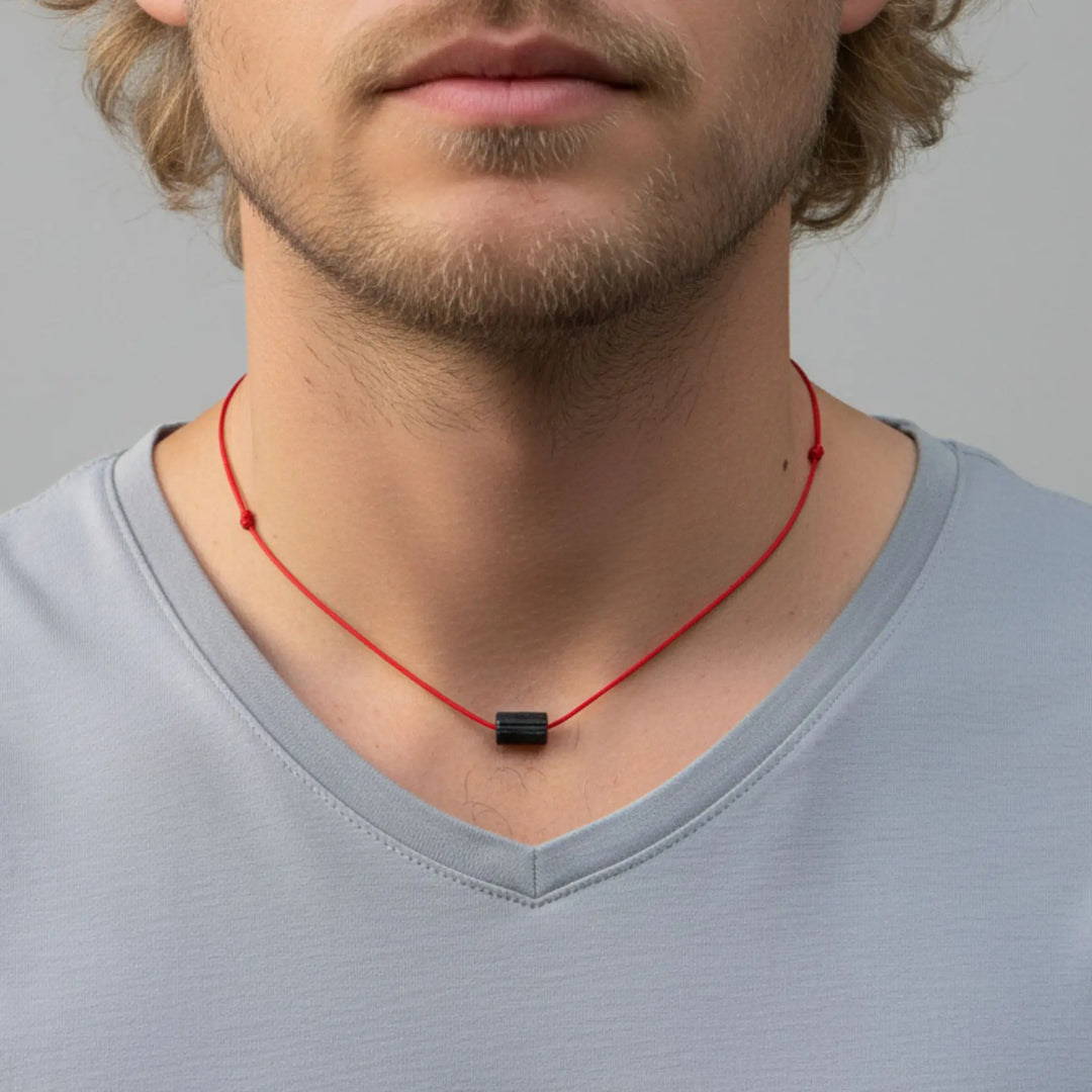Man wearing a red necklace with a Close-up of a black tourmaline pendant against a gray background