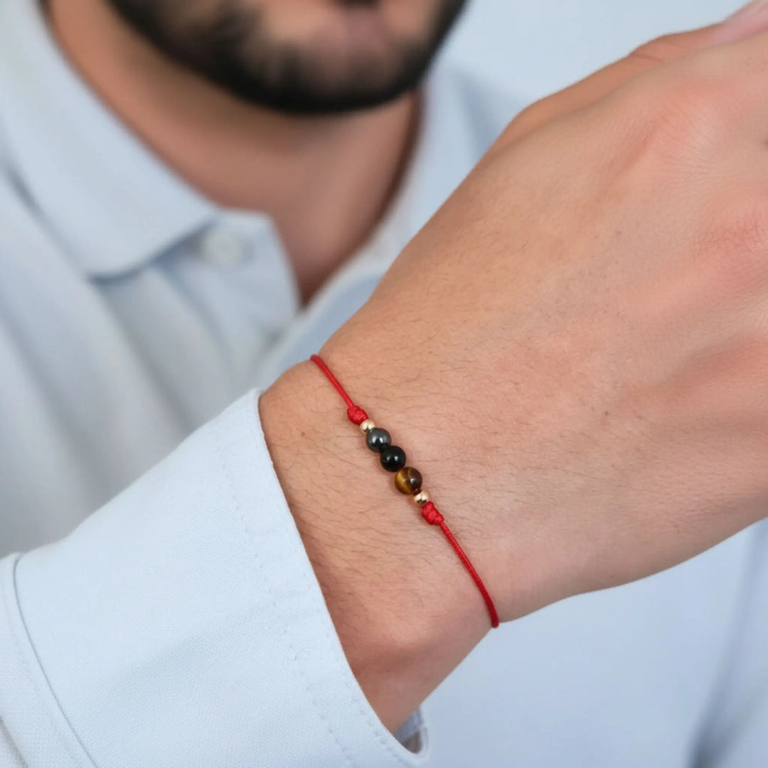 Red beaded bracelet on a wrist with a blurred background