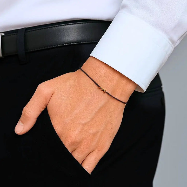 Man Wearing Solid Gold Black String Bracelet Handmade by Luck Strings