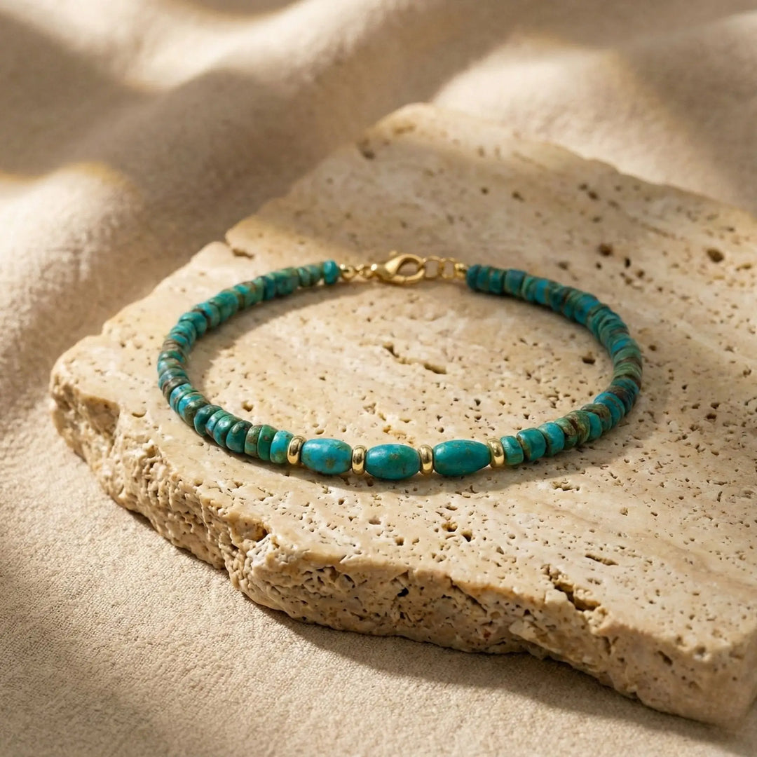 Turquoise beaded bracelet on a textured stone surface