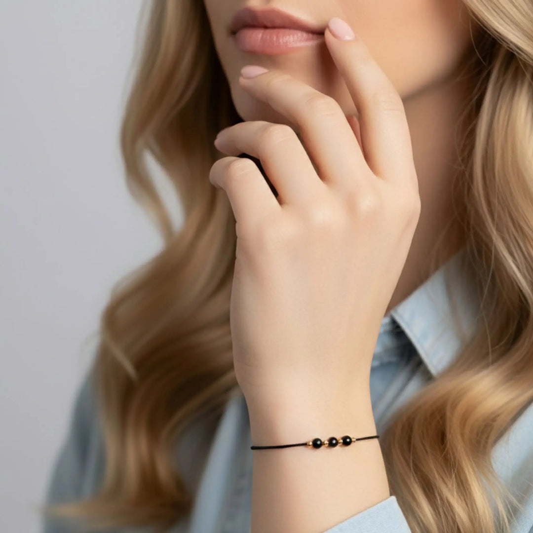 Close-up of a woman with long blonde hair and a bracelet on her wrist.