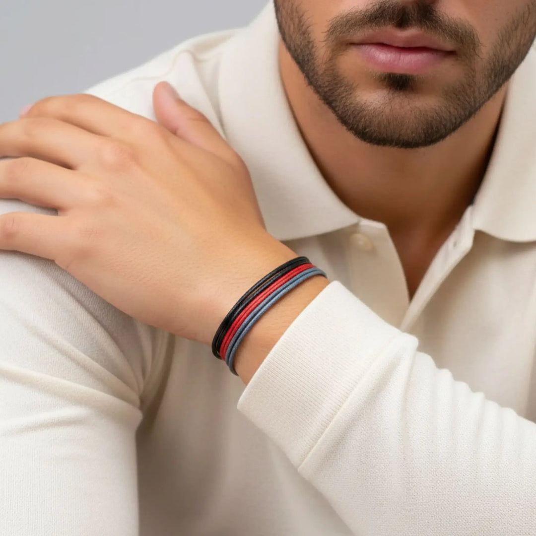 Man wearing a white shirt with a colorful bracelet on his wrist.