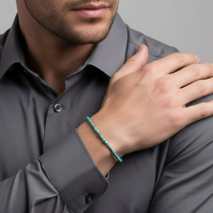 Man wearing a turquoise bracelet on a gray background