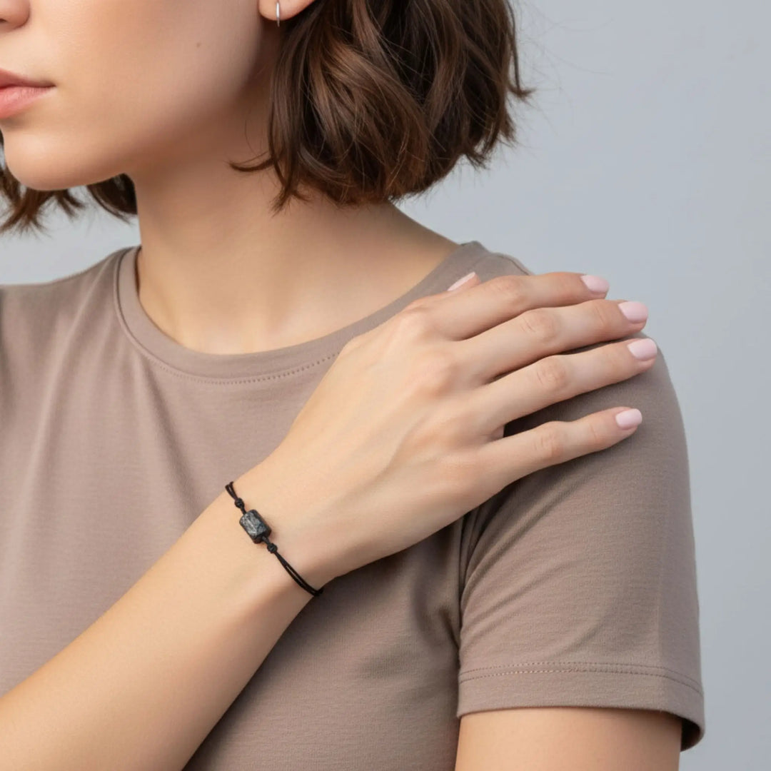 Raw black tourmaline stone bracelet on adjustable black string. Minimalist unisex jewelry and symbolic protection accessory.