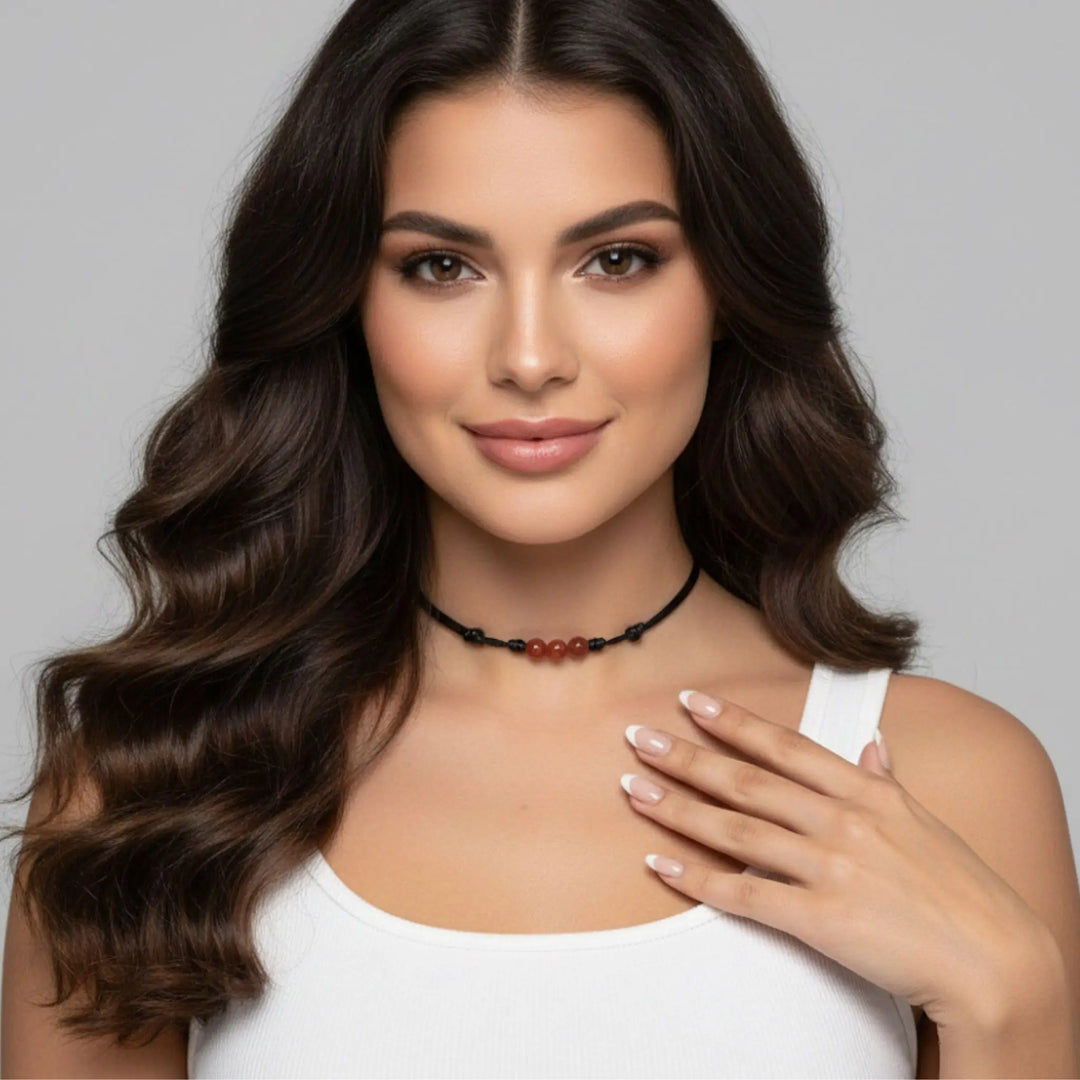 Woman wearing a carnelain necklace with a gray background
