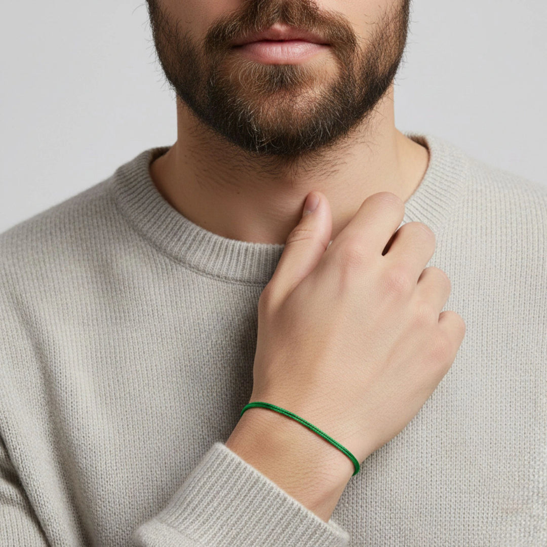 Man wearing a beige sweater with a hand touching his neck, on a light gray background