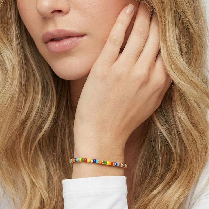 Close-up of a woman wearing a colorful bracelet on her wrist.