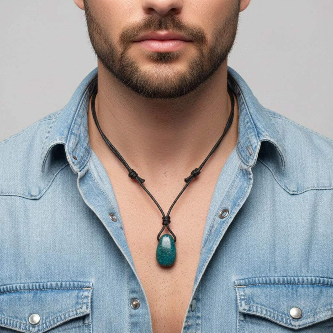 Man wearing a blue denim shirt with an Apatite necklace featuring a green pendant against a gray background