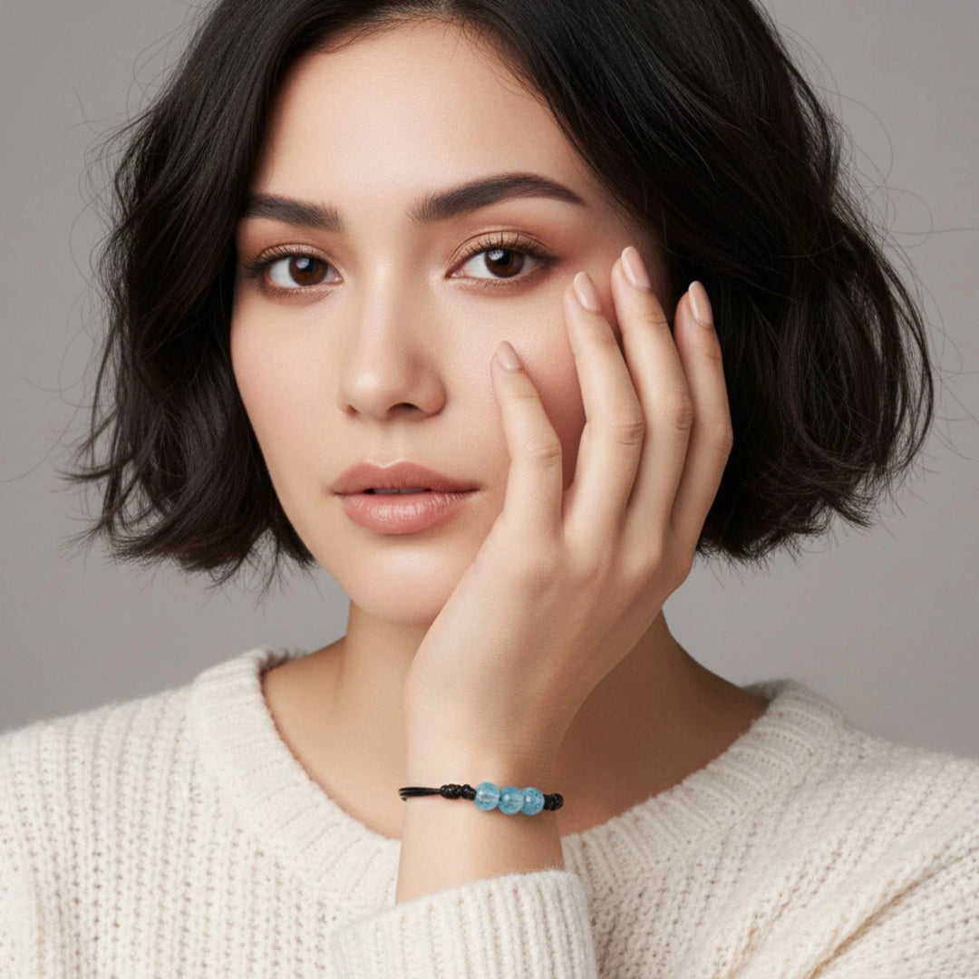 Woman wearing a glass bracelet with a gray background