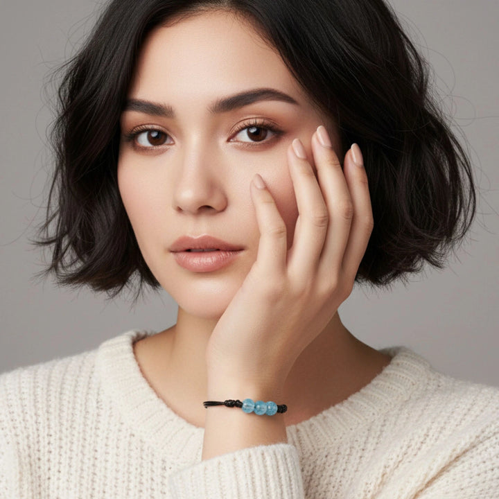 Woman wearing a glass bracelet with a gray background