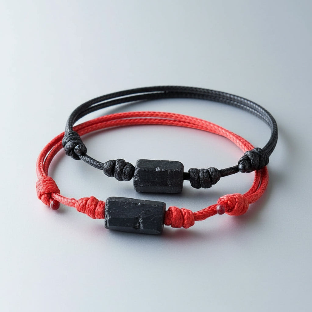 Two raw black tourmaline bead bracelets on red and black waxed nylon cords.
