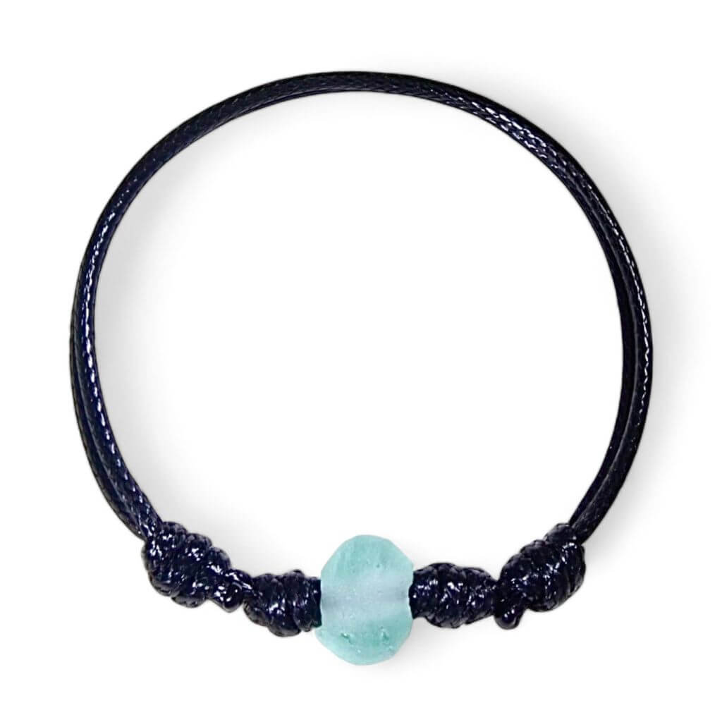 A bracelet with black cord and seafoam green beads, showcasing a loop closure.