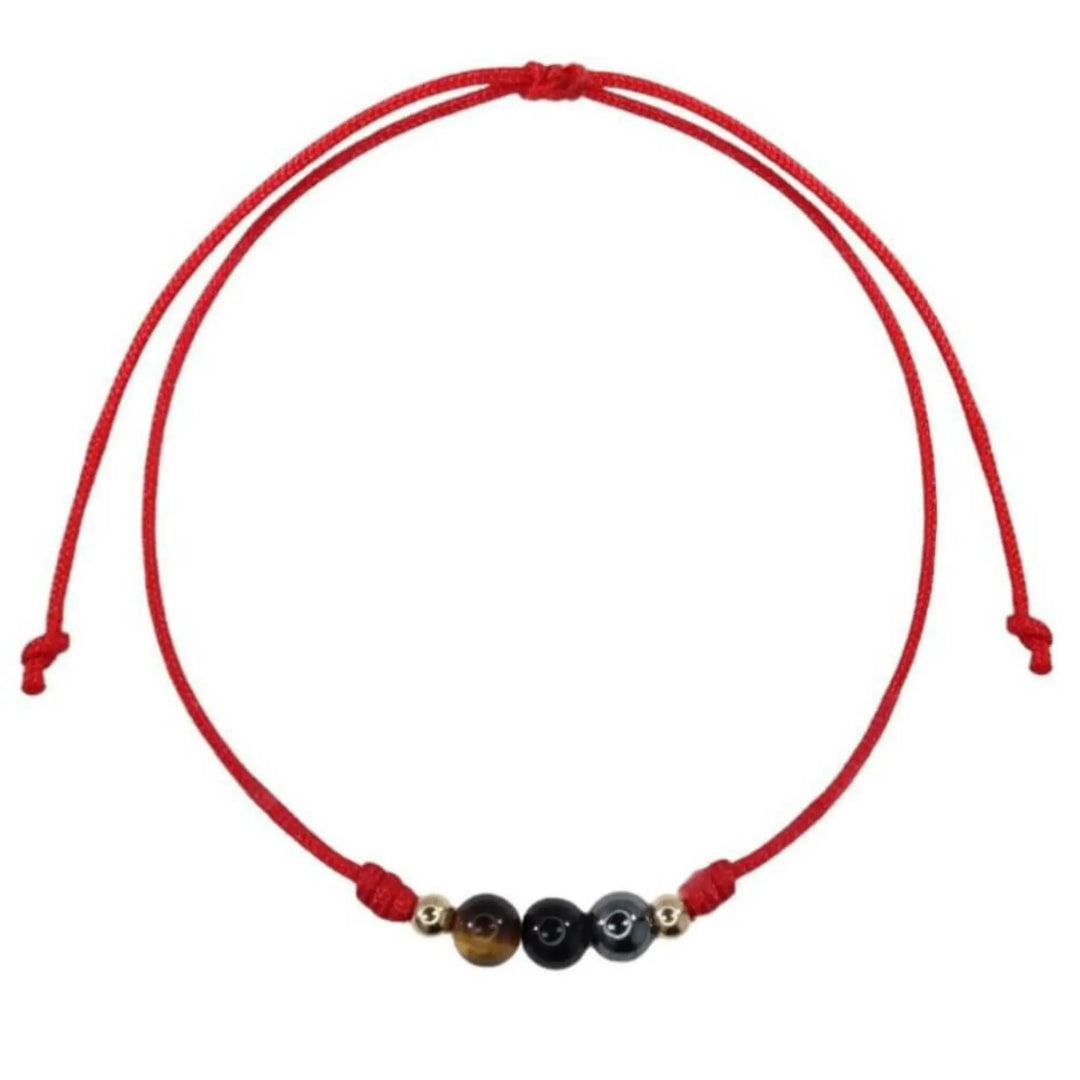 Red string bracelet with three beads on a white background