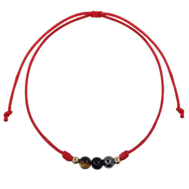 Red string bracelet with three beads on a white background