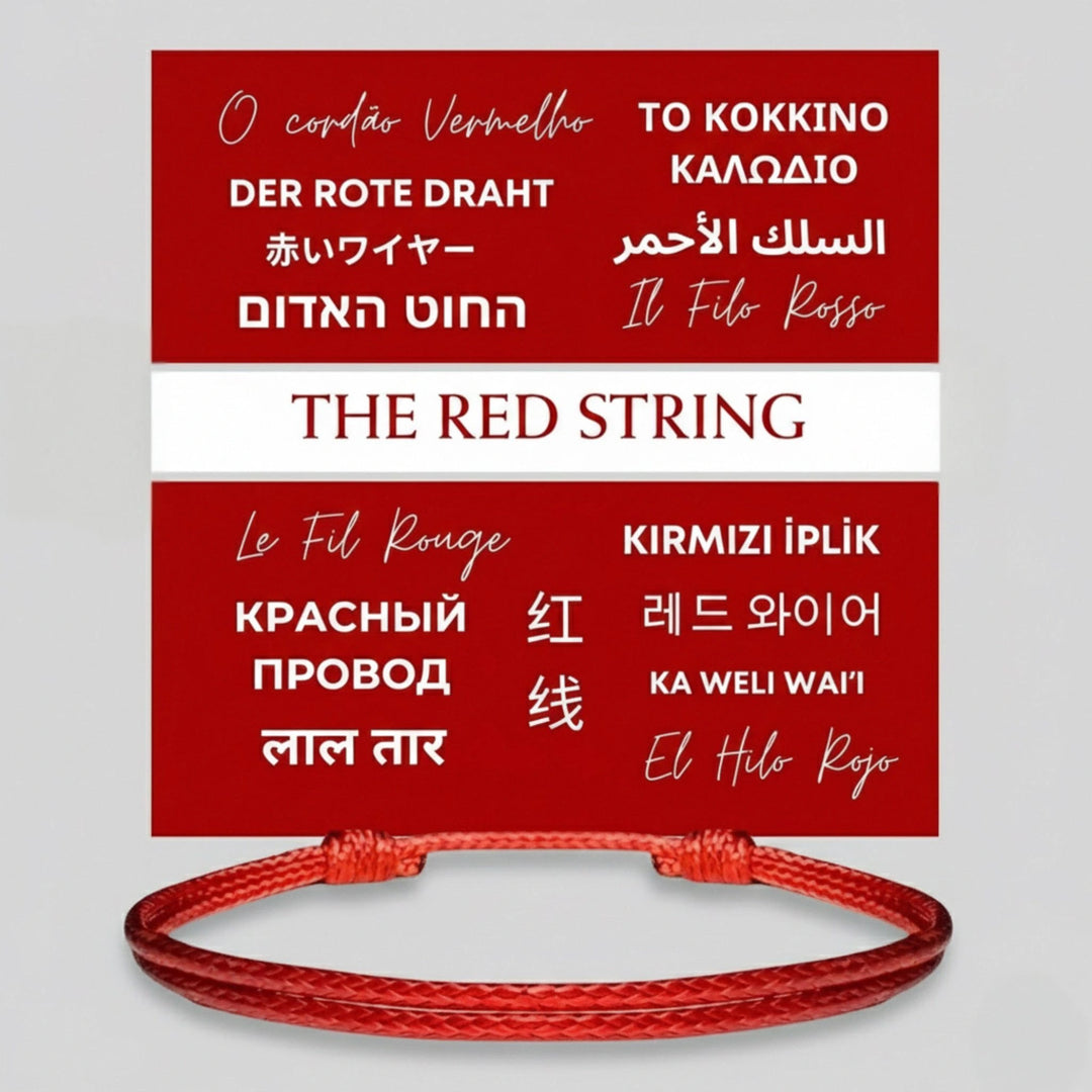 Red string bracelet with text in multiple languages on a gray background