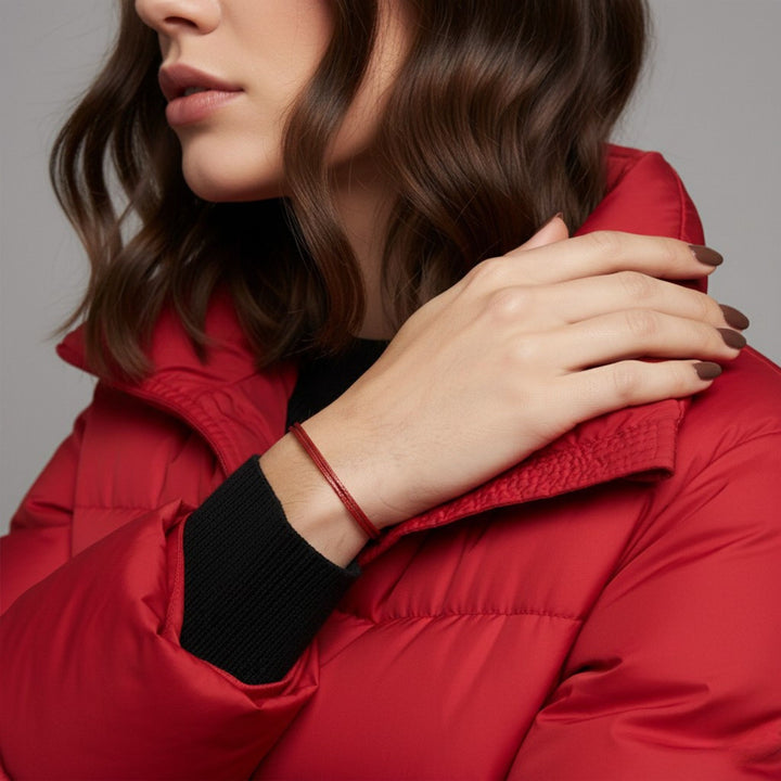 Person wearing a red puffer jacket with a neutral background