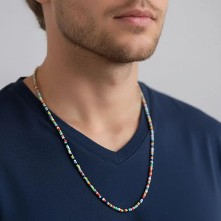 Man wearing a colorful beaded necklace against a neutral background