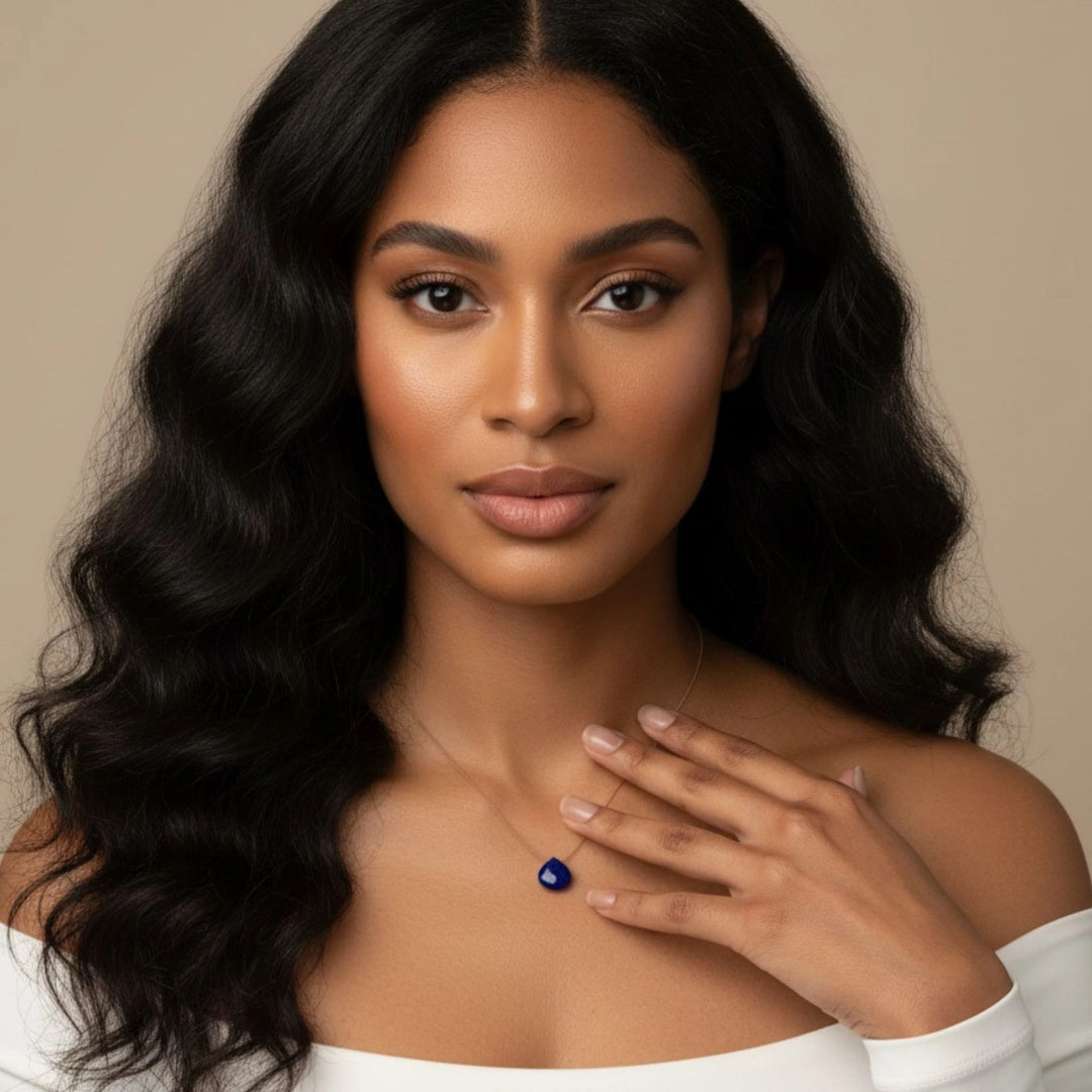 Woman wearing a lapis lazuli pendant necklace against a neutral background