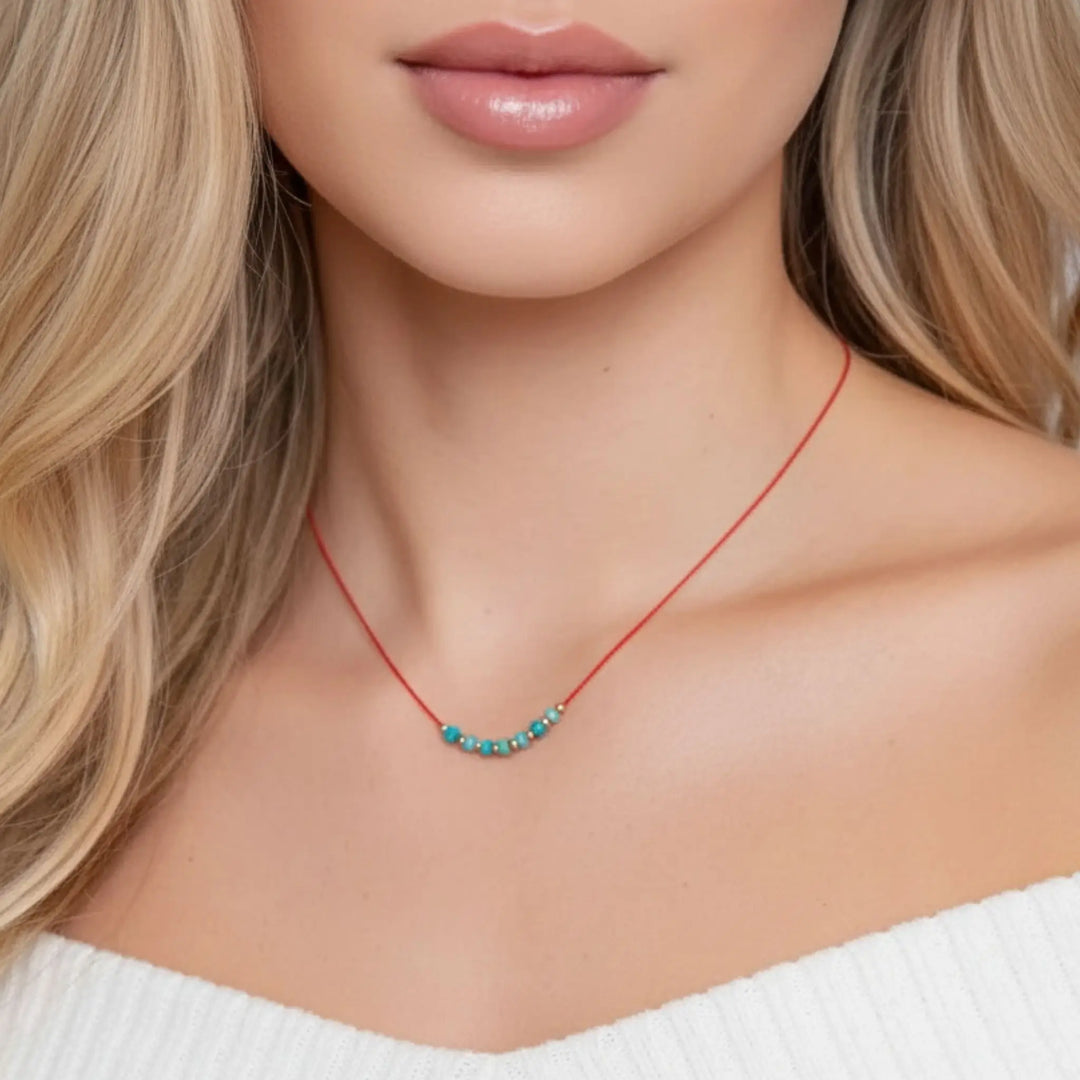 Necklace with blue beads worn by a model against a neutral background