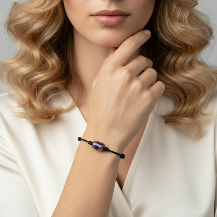 Woman wearing smooth amethyst cylinder bead bracelet on black waxed nylon cord.
