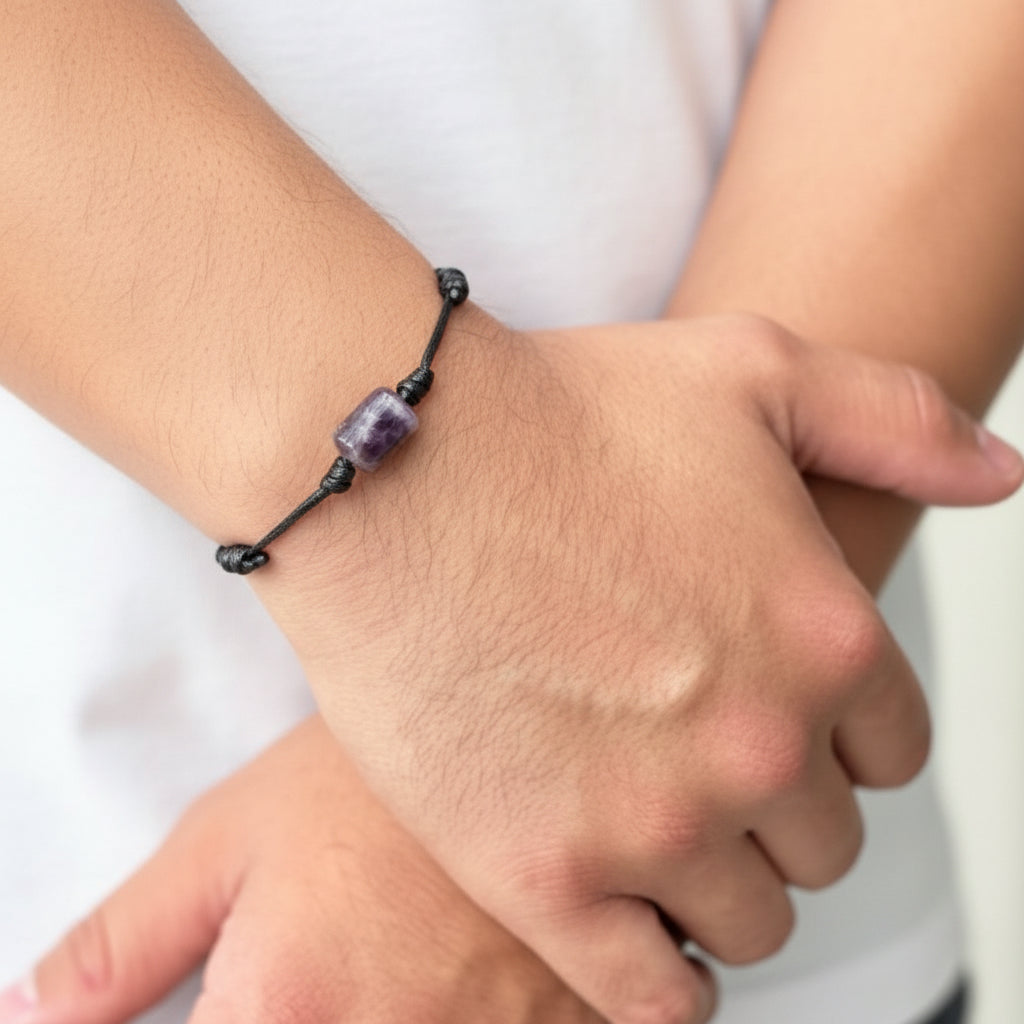 Man wearing smooth amethyst cylinder bead bracelet on black waxed nylon cord.