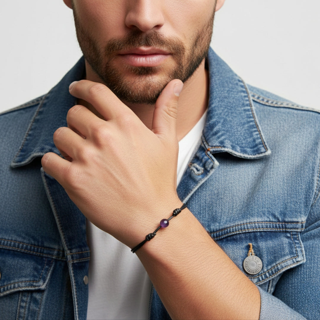 Man wearing smooth amethyst single bead bracelet on black waxed nylon cord.
