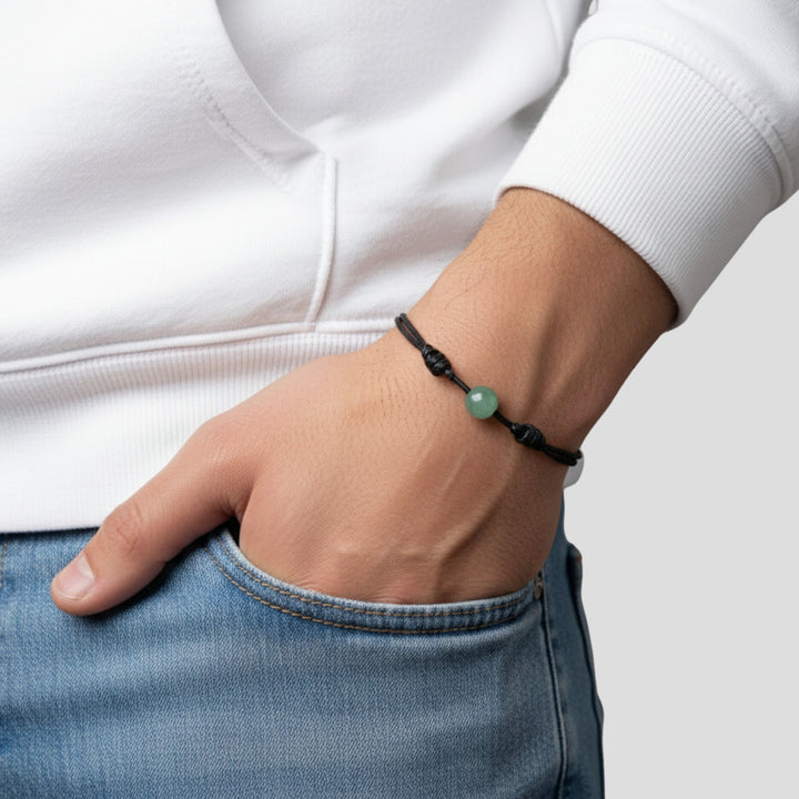 Man wearing smooth green aventurine single bead bracelet on black waxed nylon cord