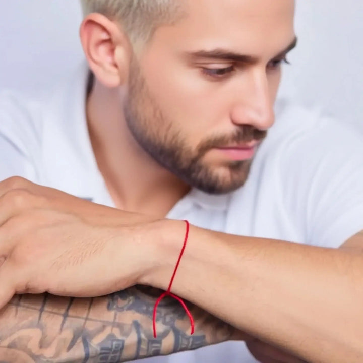 Man wearing a red bracelet with a white background