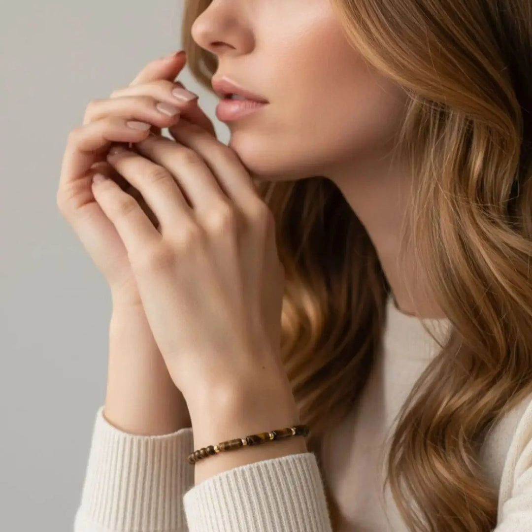 Close-up of a woman with a bracelet on her wrist against a neutral background