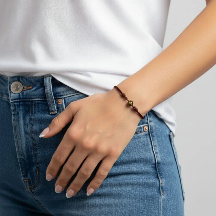 Minimalist tiger’s eye bracelet on nylon cord worn with jeans