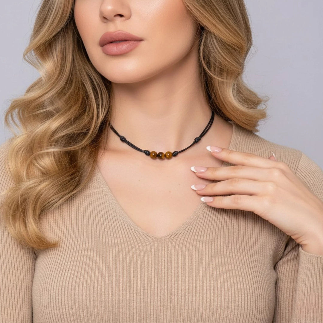 Woman wearing a black beaded necklace against a neutral background