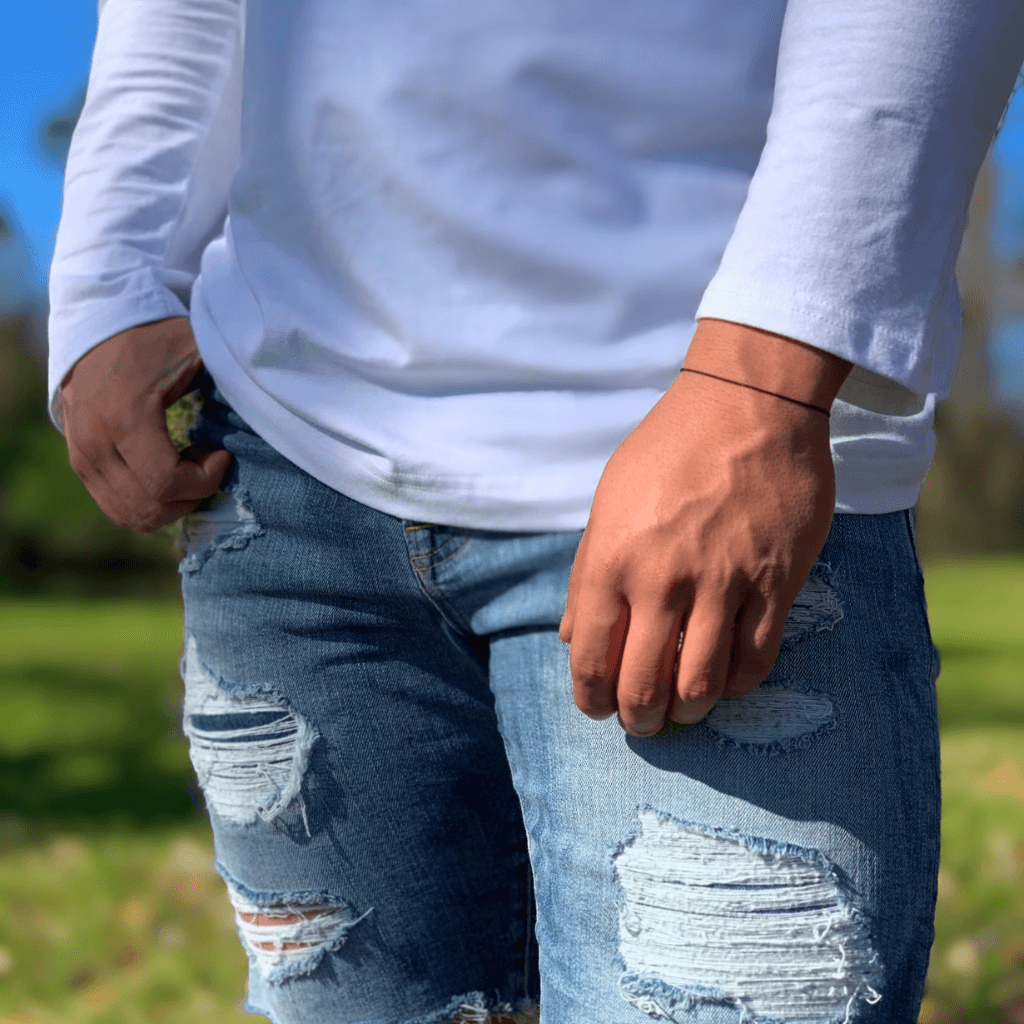 Casual look with a person wearing a black string gold clasp bracelet with jeans and a white shirt - Luck Strings.