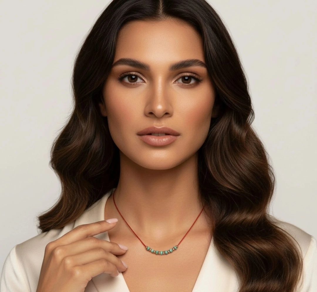 Woman wearing a turquoise necklace with a plain background