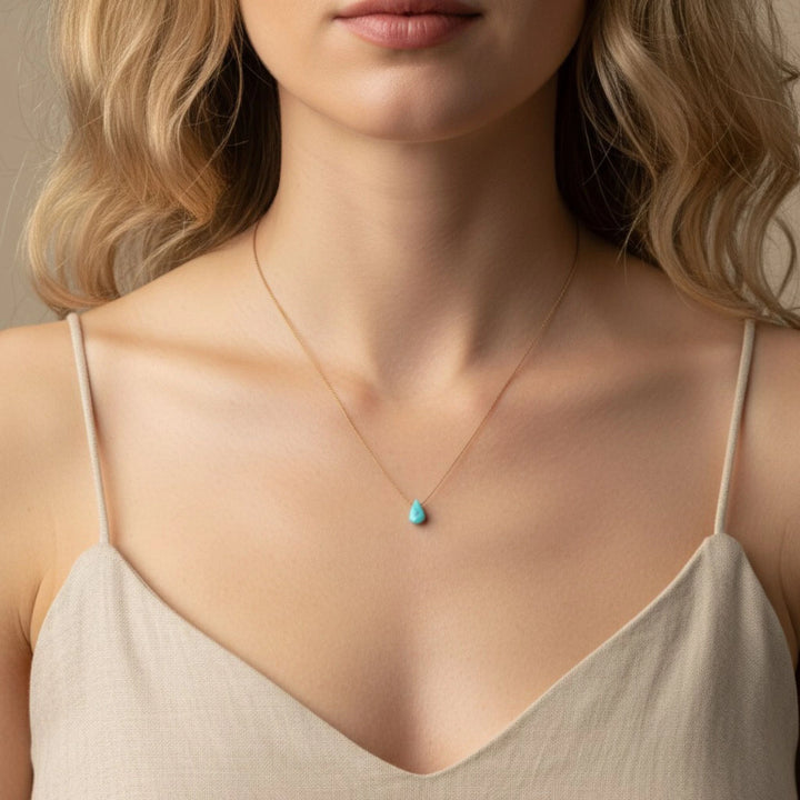 Woman wearing a necklace with a turquoise pendant
