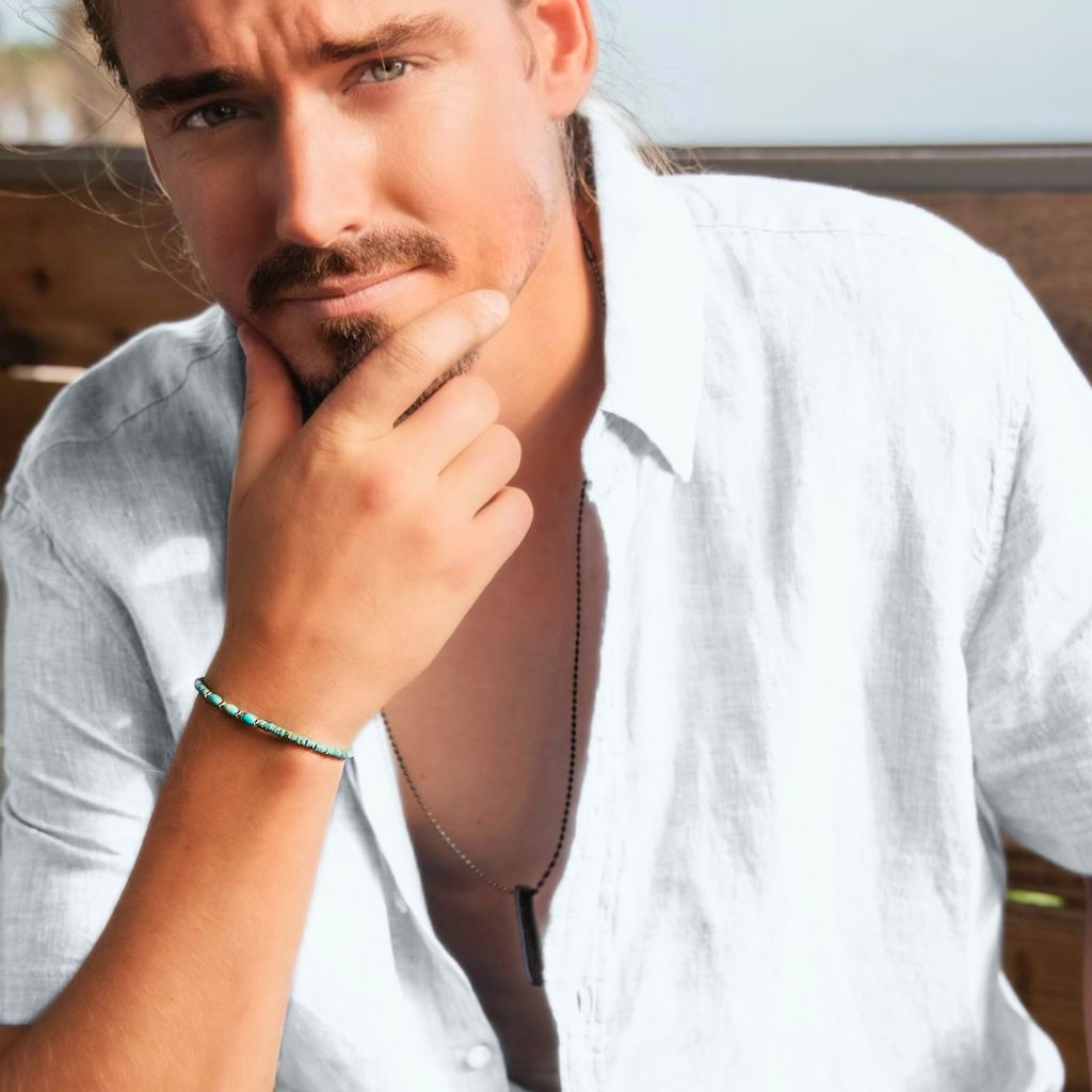 Natural turquoise heishi and solid gold bracelet on man's wrist, adding a touch of sophistication. Luck Strings